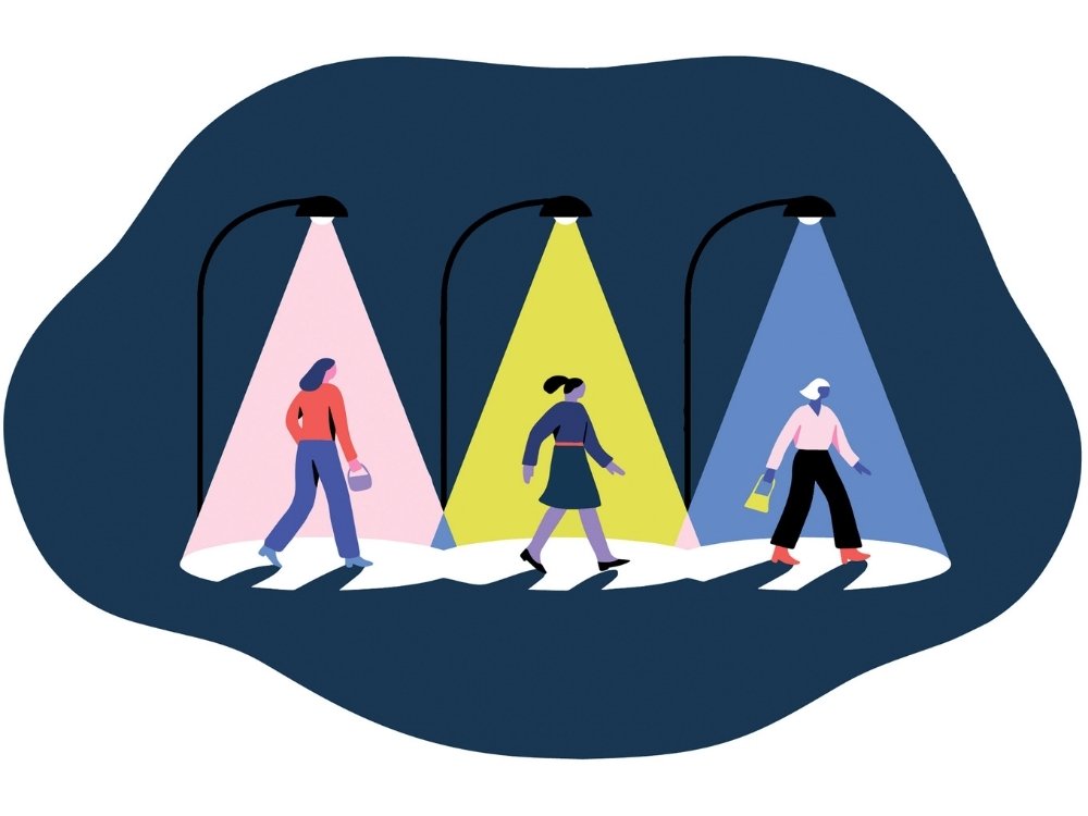 Illustration of three people walking under streetlights casting colored beams—pink, yellow, and blue—against a dark background, suggesting diversity.