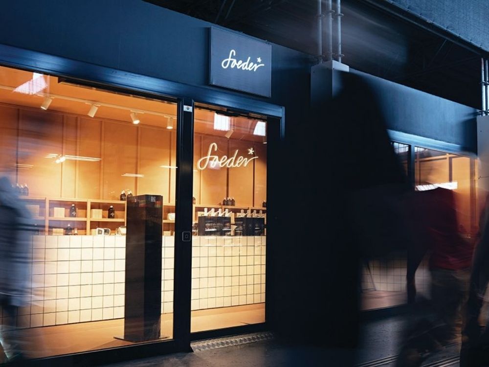 A modern storefront with a bright interior and a glowing sign reading "Soeder."