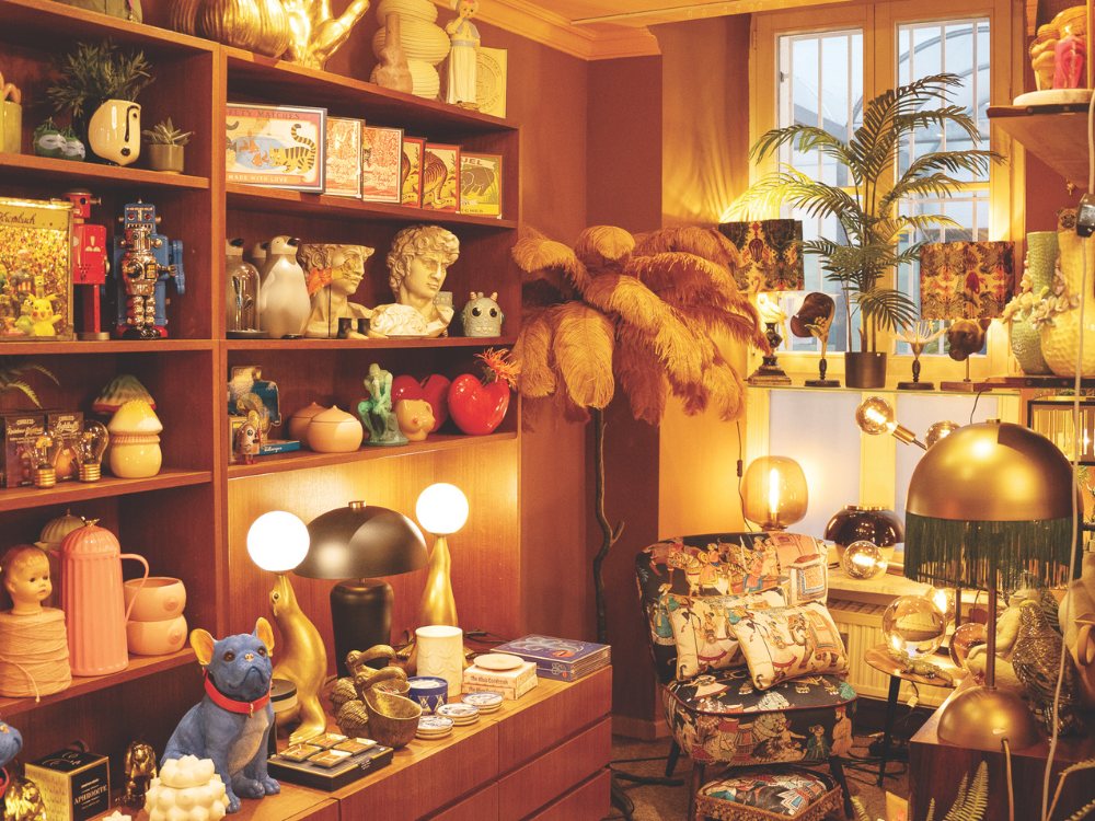 A cozy, eclectic room filled with vintage decor, colorful trinkets, and retro lamps. Warm lighting creates a nostalgic, inviting atmosphere.