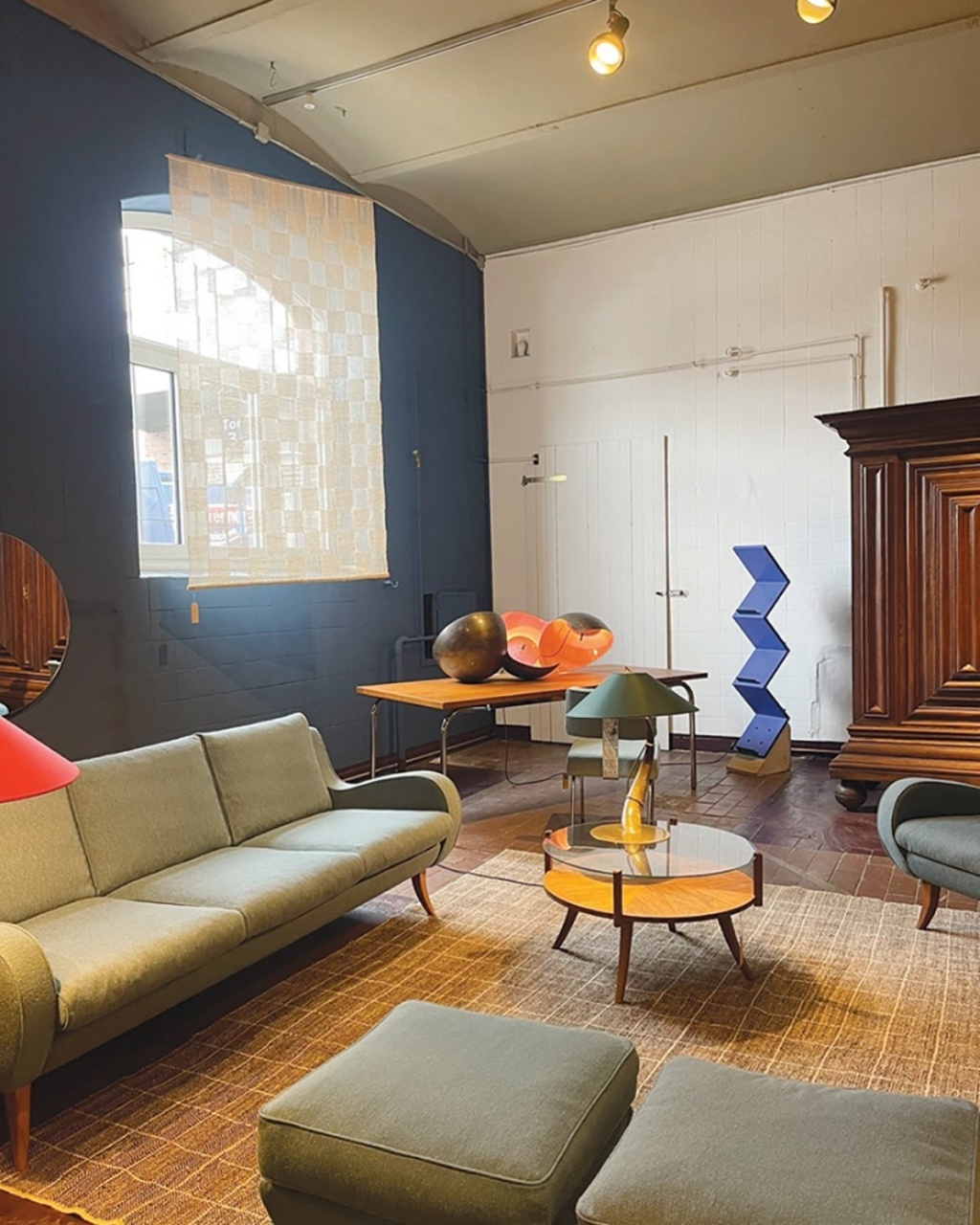 Modern interior featuring a green sofa, glass coffee table, colorful decor, and a variety of textures in a stylish setting.
