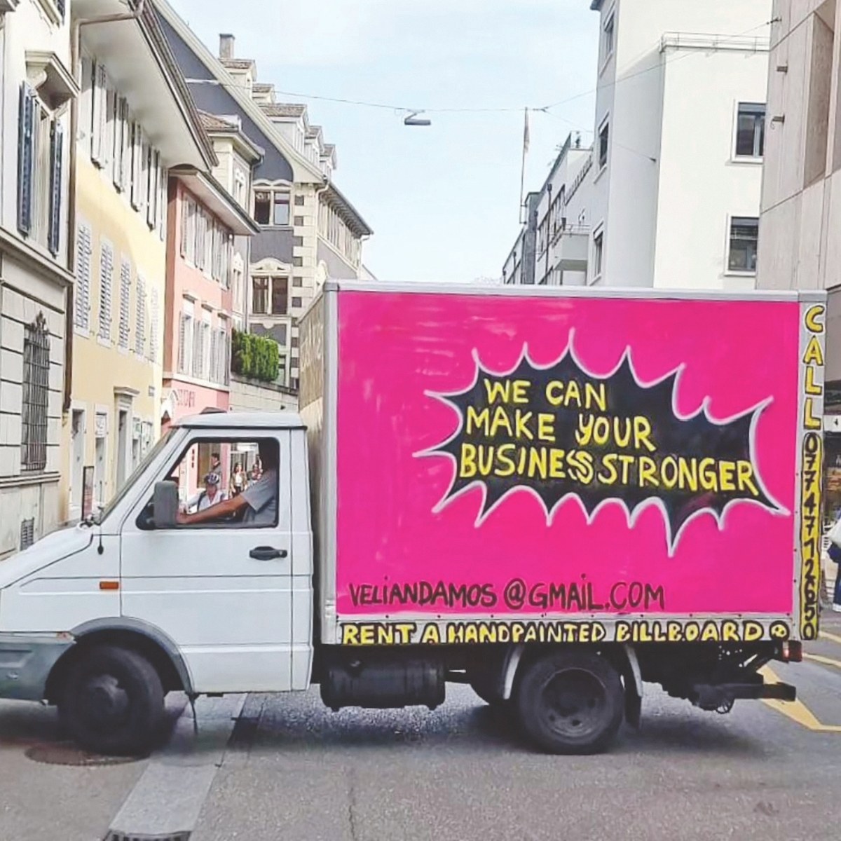 A white delivery truck with a bright pink billboard on the side, advertising business services and contact information.